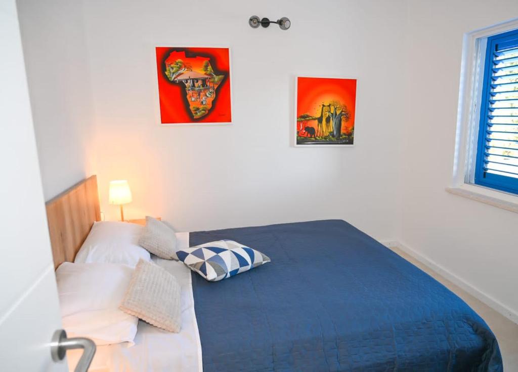 a bedroom with a bed and two pictures on the wall at Apartment Leo Blue in Vela Luka