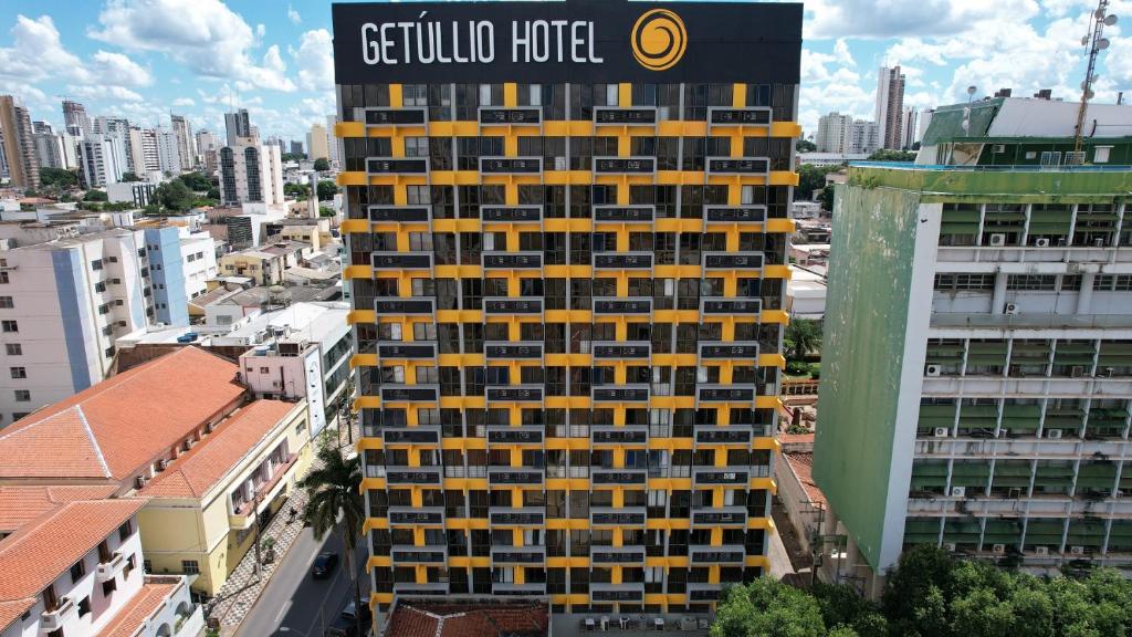 un grand bâtiment jaune et noir dans une ville dans l'établissement Getúllio Hotel, à Cuiabá