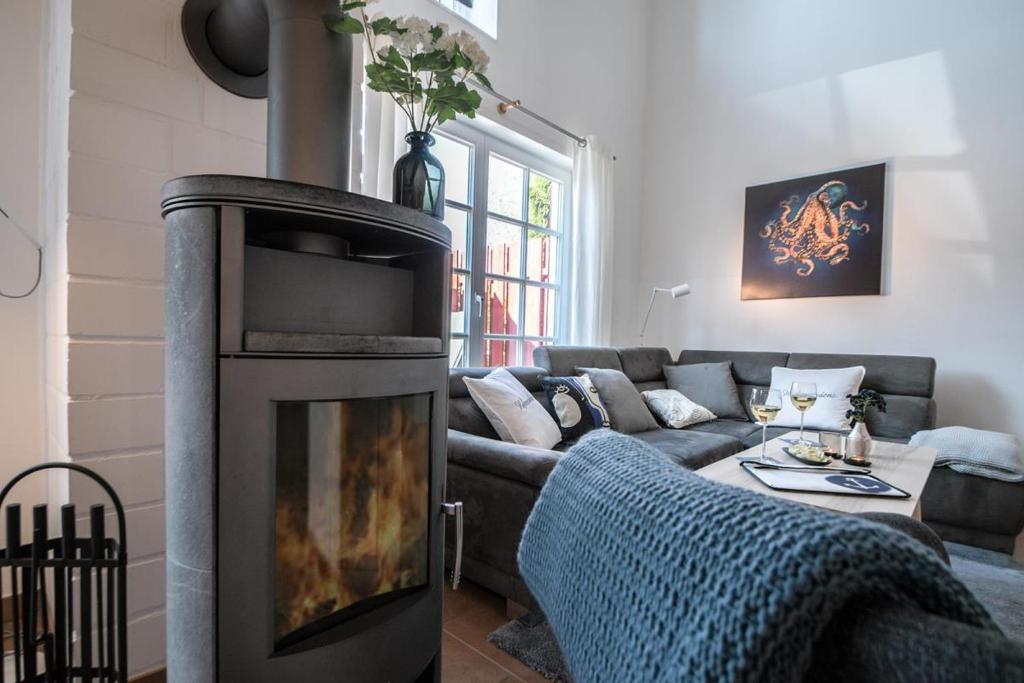 a living room with a couch and a fireplace at Ferienhaus Hafenresidenz in Greetsiel