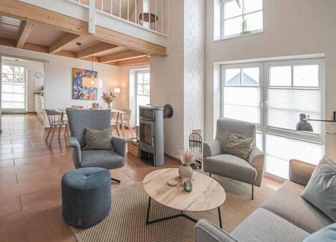 een woonkamer met een bank, stoelen en een tafel bij Hafenparadies in Greetsiel