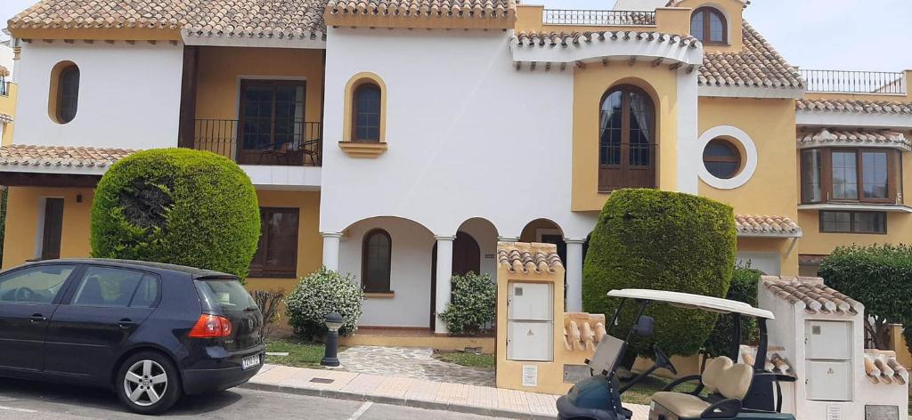 a black car parked in front of a house at La Manga Club Townhouse in Cartagena