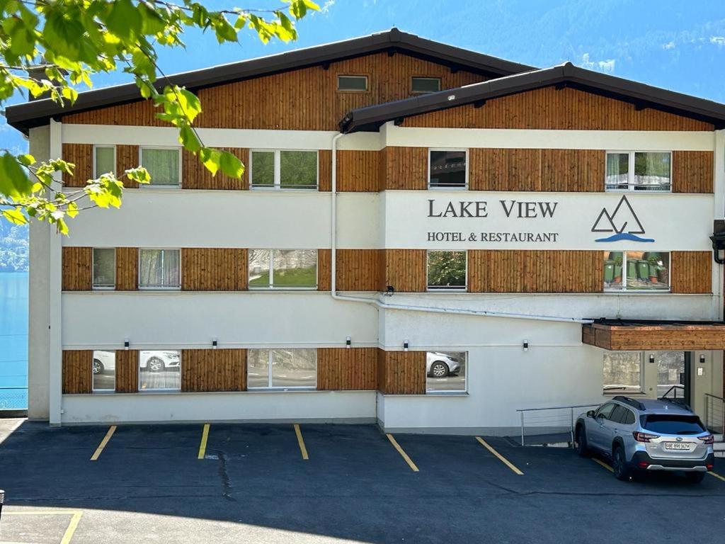 un bâtiment avec une voiture garée sur un parking dans l'établissement Hotel Lakeview bei Interlaken, à Interlaken