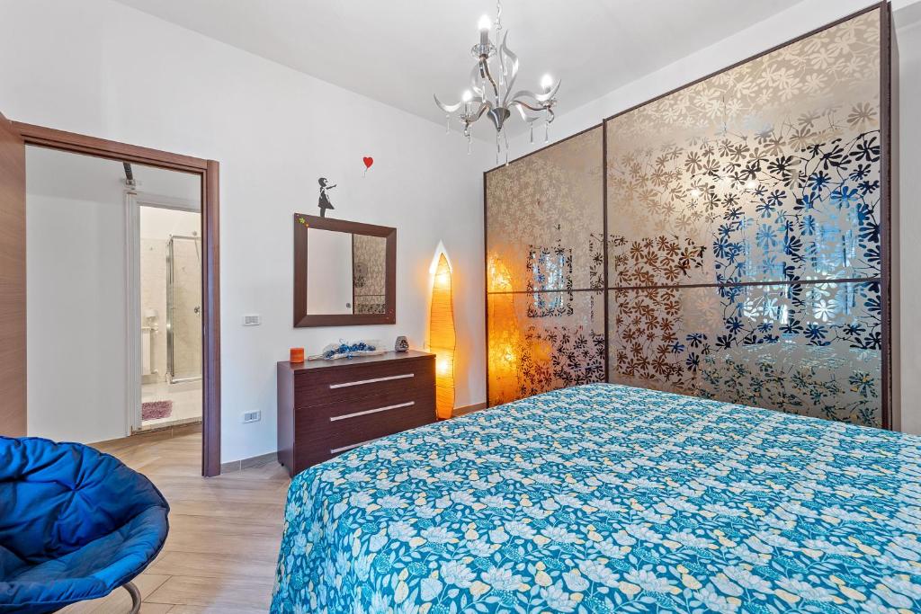 - une chambre avec un lit et une peinture murale dans l'établissement La Casa di Alice, à Carbonia