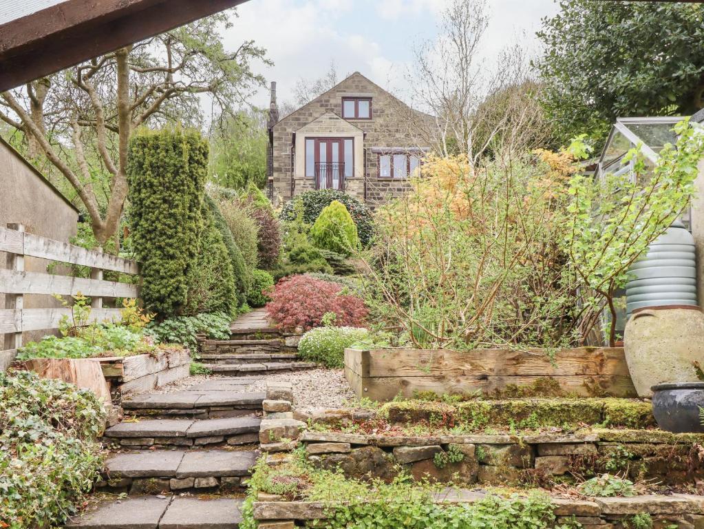 a garden with stone steps leading to a house at Windyways in Keighley