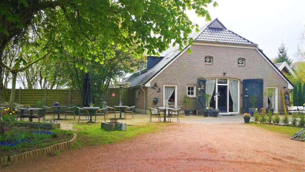 una casa con mesas y sillas frente a ella en Bij Aquamarijn, en Stieltjeskanaal