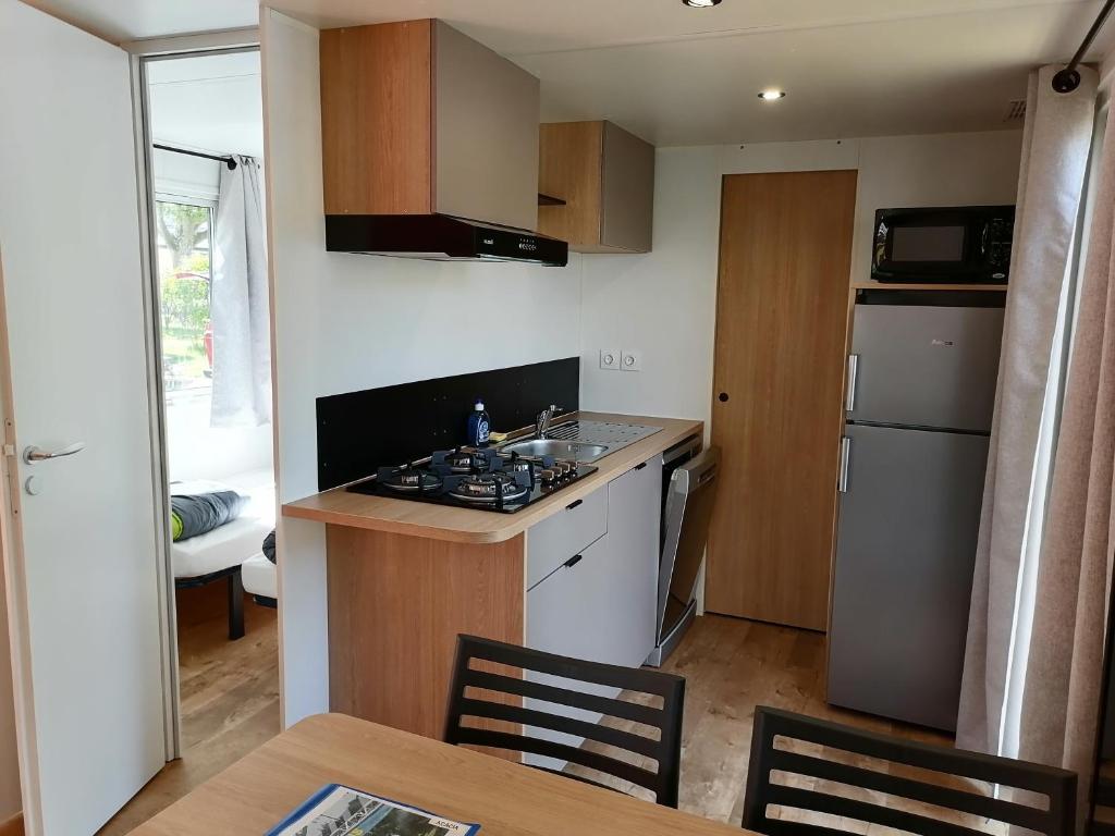 a small kitchen with a sink and a stove at Camping le Rhône in Tournon-sur-Rhône