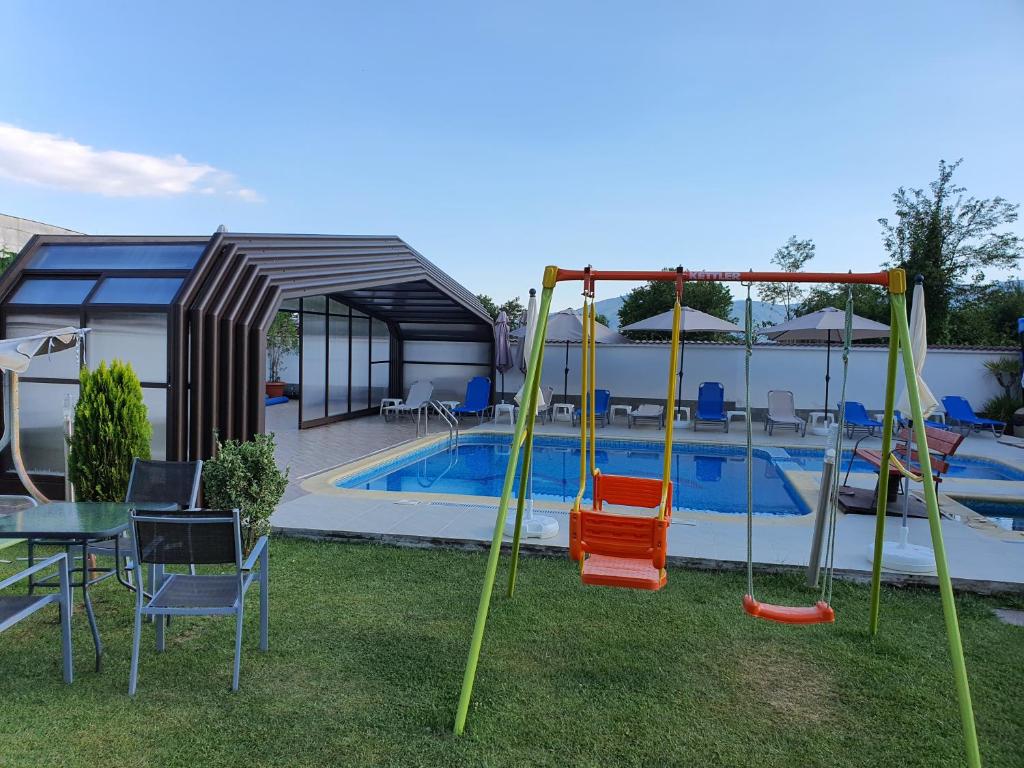 a backyard with a swimming pool with a swing at White House in Ognyanovo