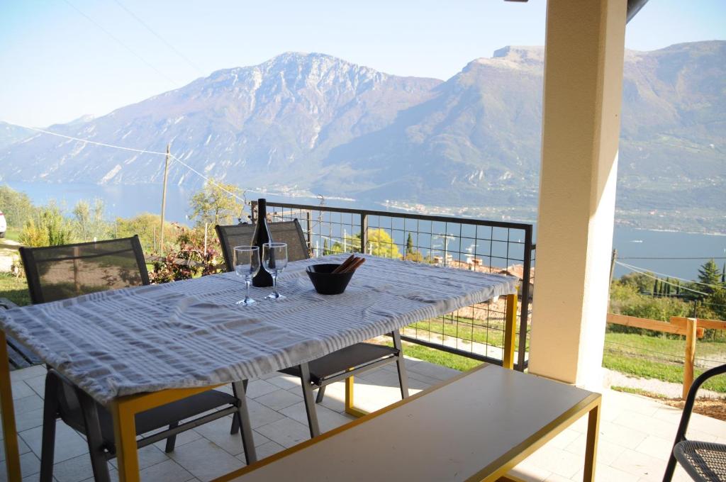 un tavolo su un balcone con vista sulle montagne di Villetta 56 Blu Yellow and Red Lake view Garden Private Parking by Garda Domus Mea a Tremosine Sul Garda