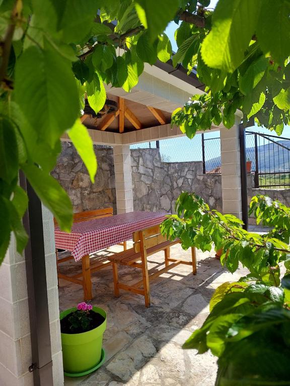 a picnic table and bench on a patio at Apartman Dorotea in Trebinje