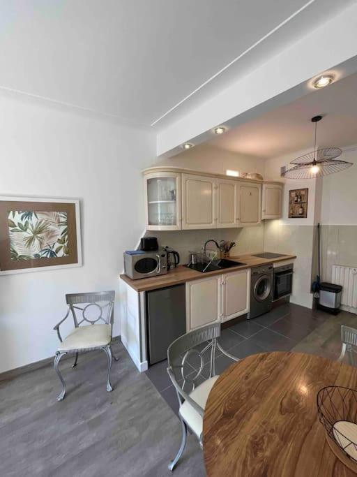 une cuisine avec une table et des chaises dans une pièce dans l'établissement Appartement atypique et original, à Nice