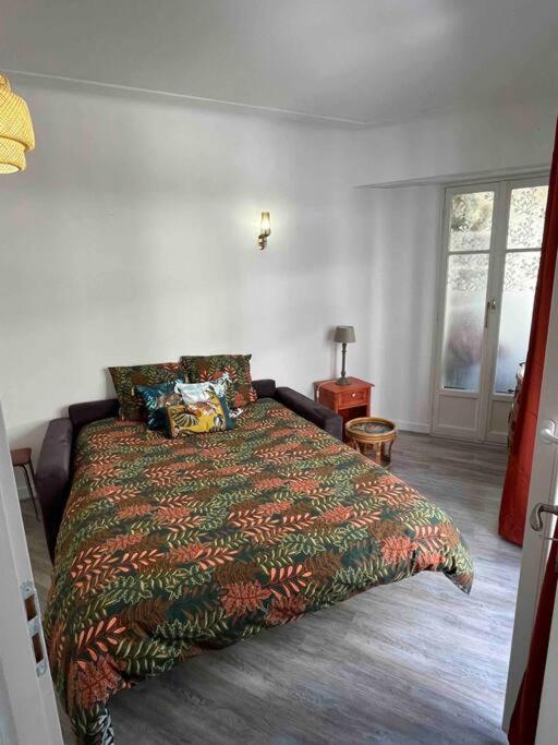 a bedroom with a large bed with a colorful blanket at Appartement atypique et original in Nice