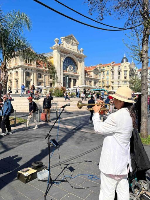 a woman playing a trombone on a street at Appartement atypique et original in Nice