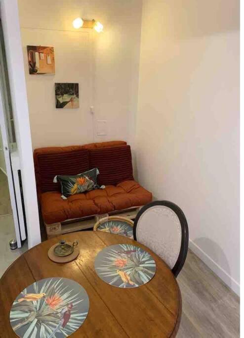 a room with a table and two chairs and a couch at Appartement atypique et original in Nice