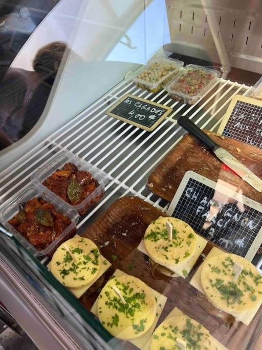 a display case with cheese and other food items at Appartement atypique et original in Nice