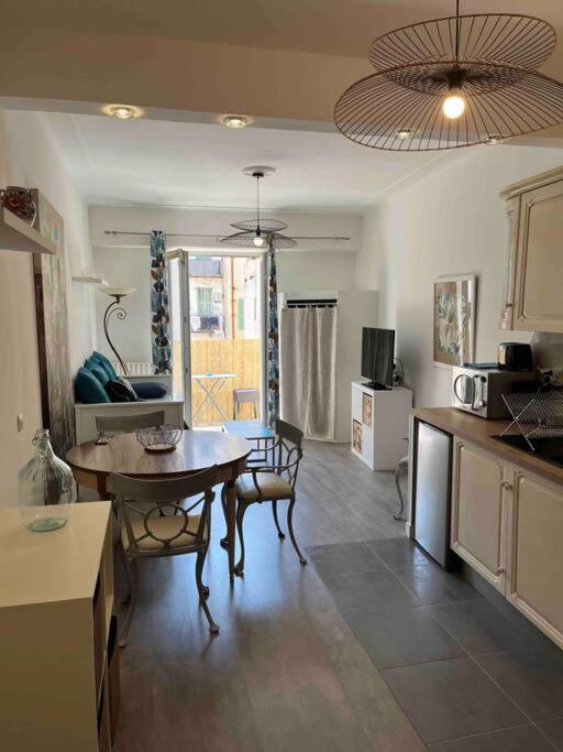 a kitchen with a table and a dining room at Appartement atypique et original in Nice