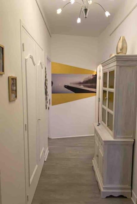 a room with a cabinet and a painting on the wall at Appartement atypique et original in Nice