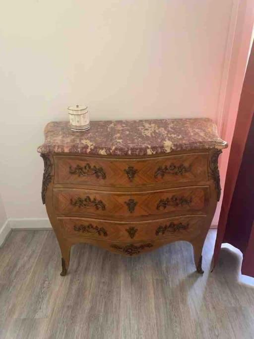 a wooden dresser with a cup on top of it at Appartement atypique et original in Nice