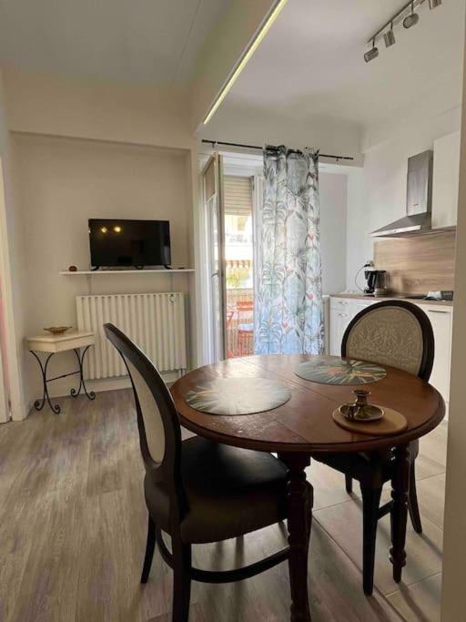 a kitchen with a wooden table and chairs in a room at Appartement atypique et original in Nice