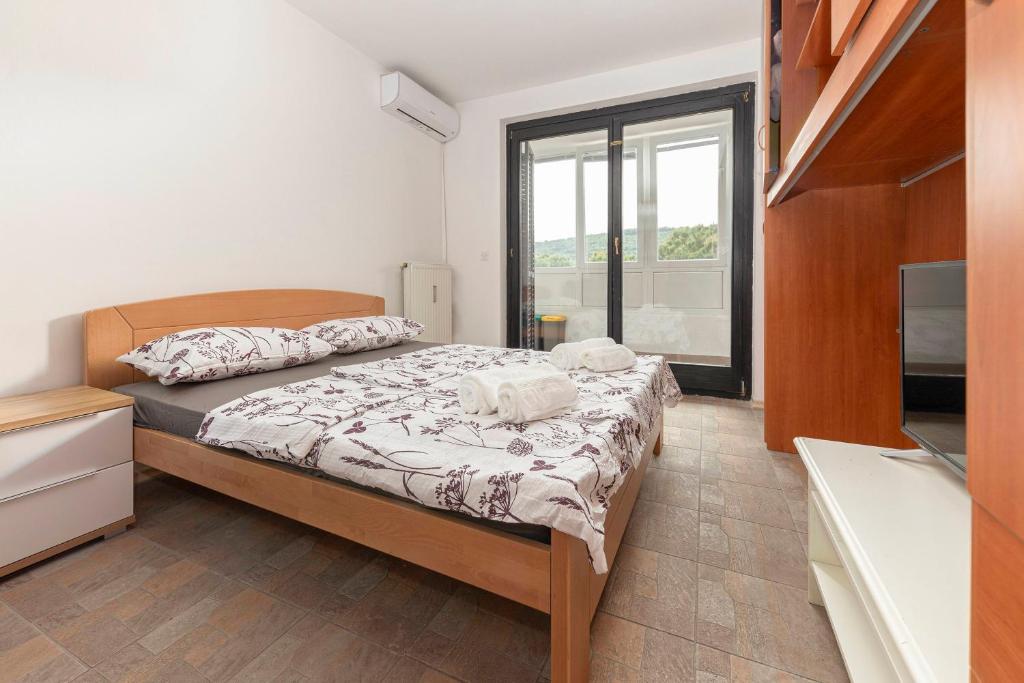 a small bedroom with a bed and a television at Studio Sirena in Izola