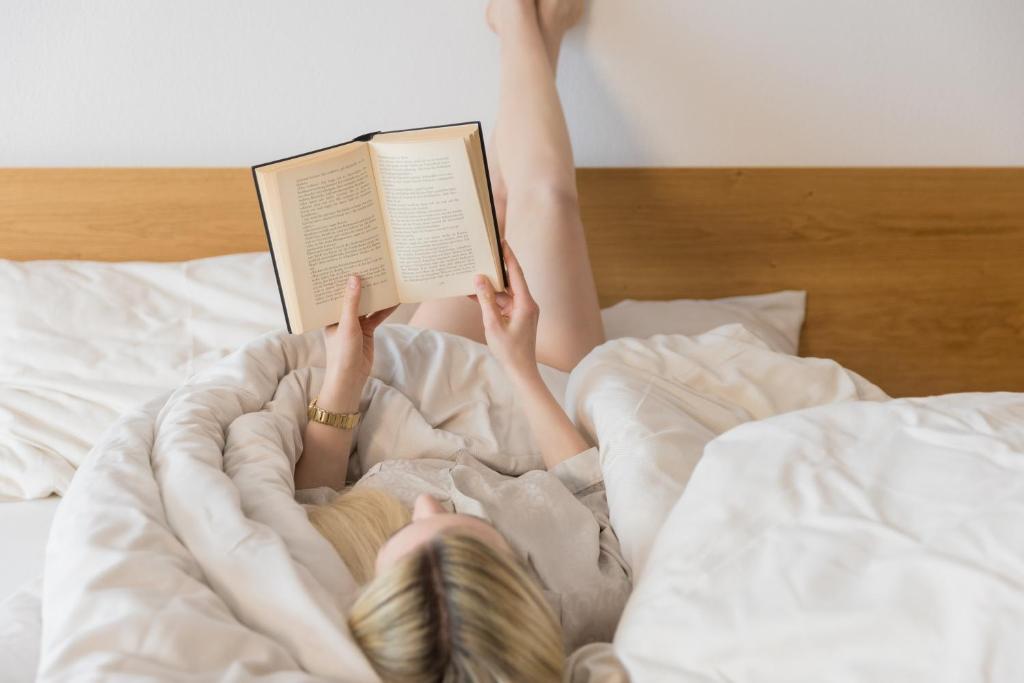 Eine Frau, die im Bett liegt und ein Buch liest. in der Unterkunft Residenz Schiestl in Fügenberg