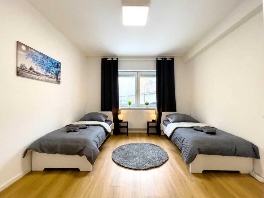 a bedroom with three beds and a window at Cosy & Central Apartments in Gelsenkirchen