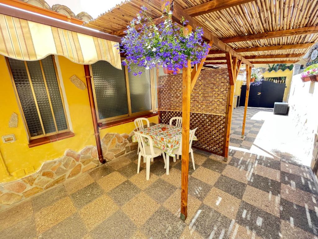 a table and chairs on a patio with a ceiling at Appartamento Nassia 2 By La Via Del Mare Viaggi e Vacanze in Villasimius