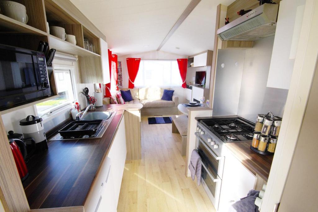 una pequeña cocina y sala de estar en una pequeña casa en Lovely 2-Bed Static Caravan in Rhyl en Rhyl