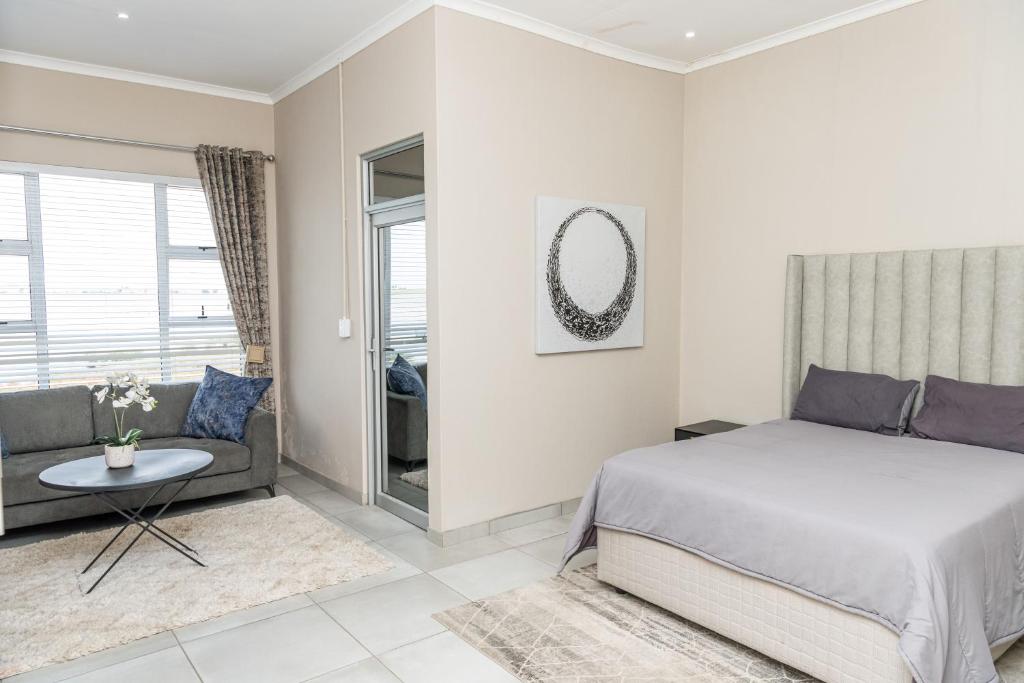 a bedroom with a bed and a couch at 36 Emanzini Villa in Denysville