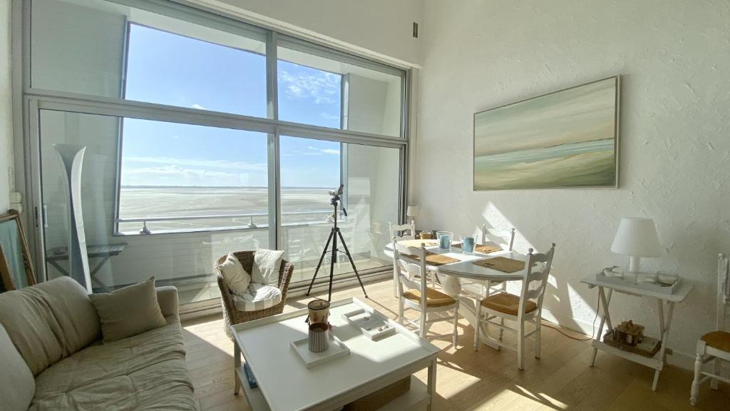 un salon avec un canapé et une table dans l'établissement Les Pieds dans l'Eau, vue sur la baie pour 6 pers, au Crotoy