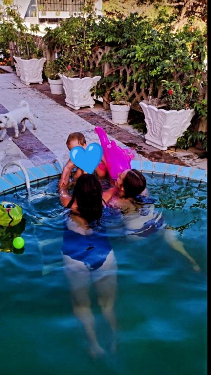 two people in a swimming pool with a heart balloon at Apartman LOKI in Ulcinj