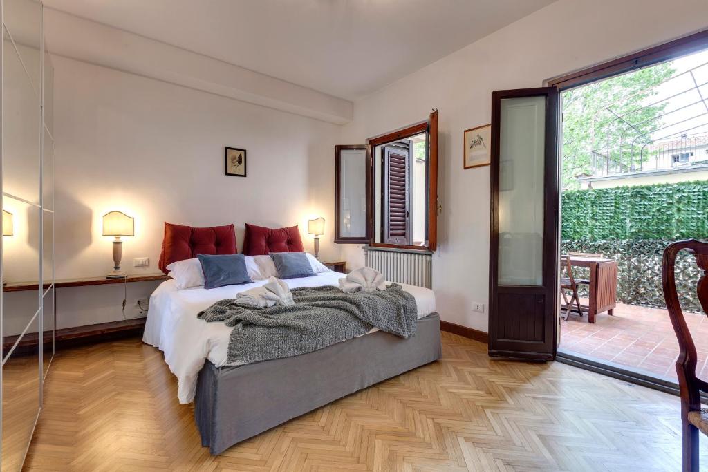 a bedroom with a large bed and a large window at Alfani Deluxe Apartment by Mamo Florence in Florence