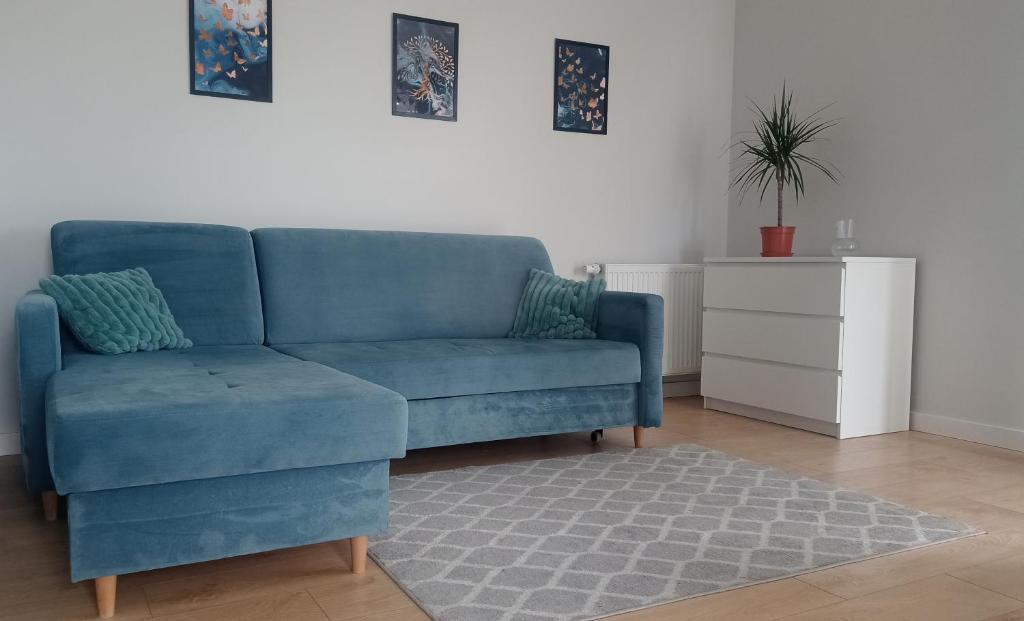 un sofá azul sentado en una sala de estar en Apartament targowy, en Poznan