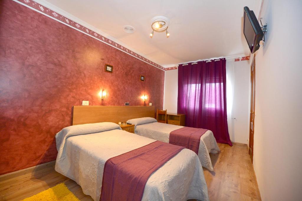 um quarto de hotel com duas camas e uma televisão em Santa Cruz em Ribadeo