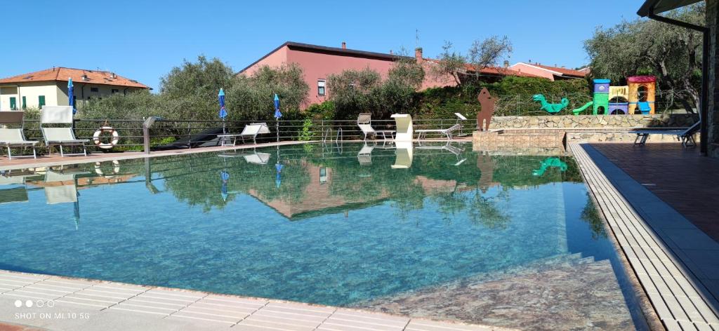 a large swimming pool with blue water in a yard at Campeggio Gianna Golfo dei Poeti in Lerici