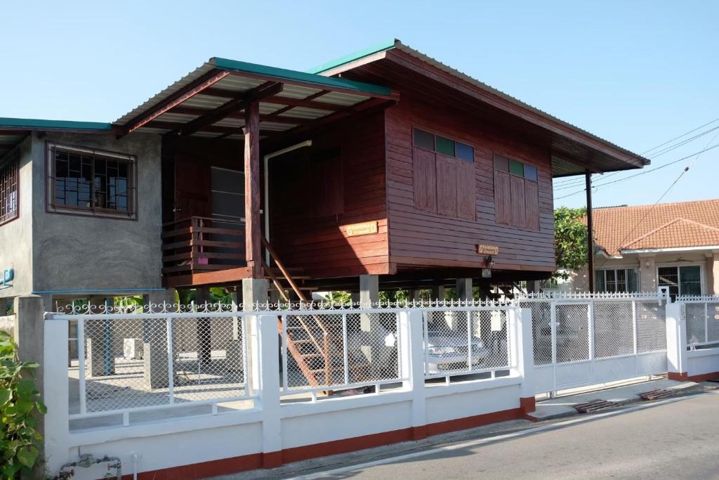 uma casa com uma cerca branca em frente em GrandmaD em Chiang Rai