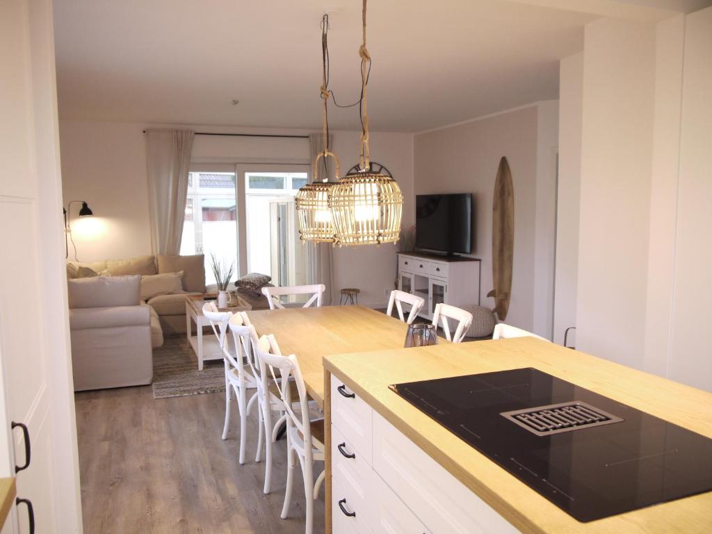 een keuken en een woonkamer met een tafel en stoelen bij Ferienhaus Haffliebe in Scharbeutz