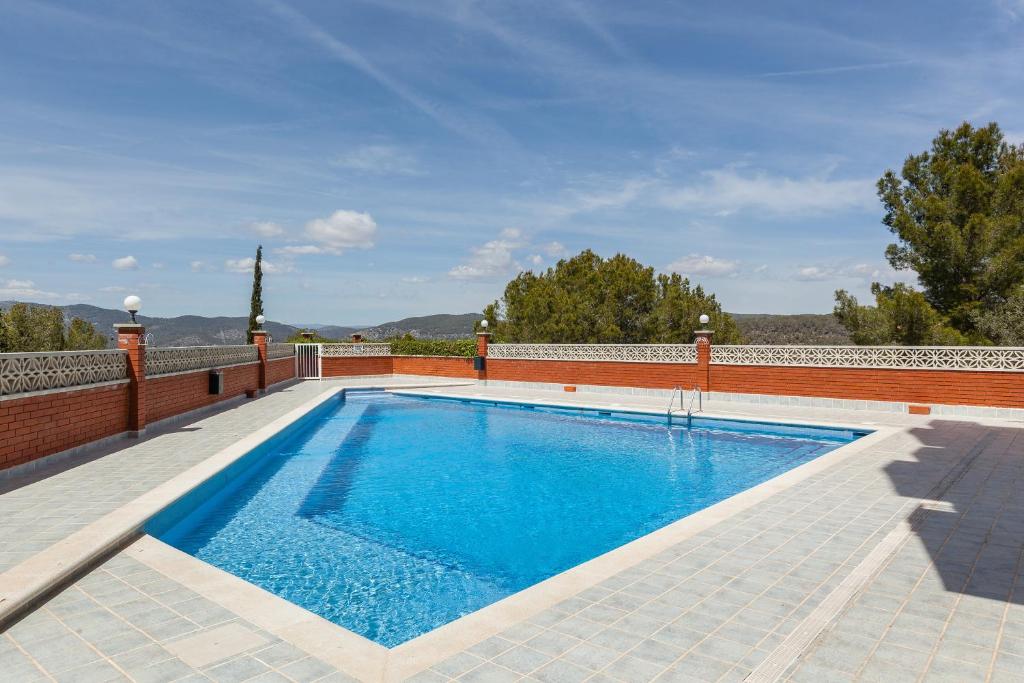 a swimming pool in a house with a brick wall at Tres Terrazas in Sant Pere de Ribes