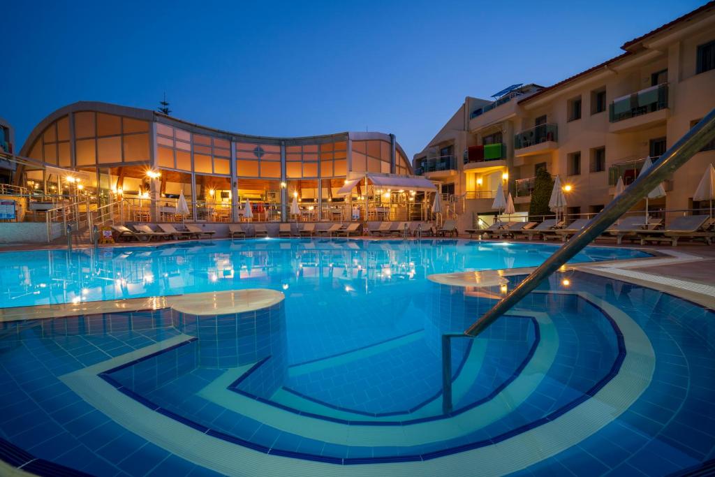 a large swimming pool in front of a building at Belcehan Hotel in Oludeniz