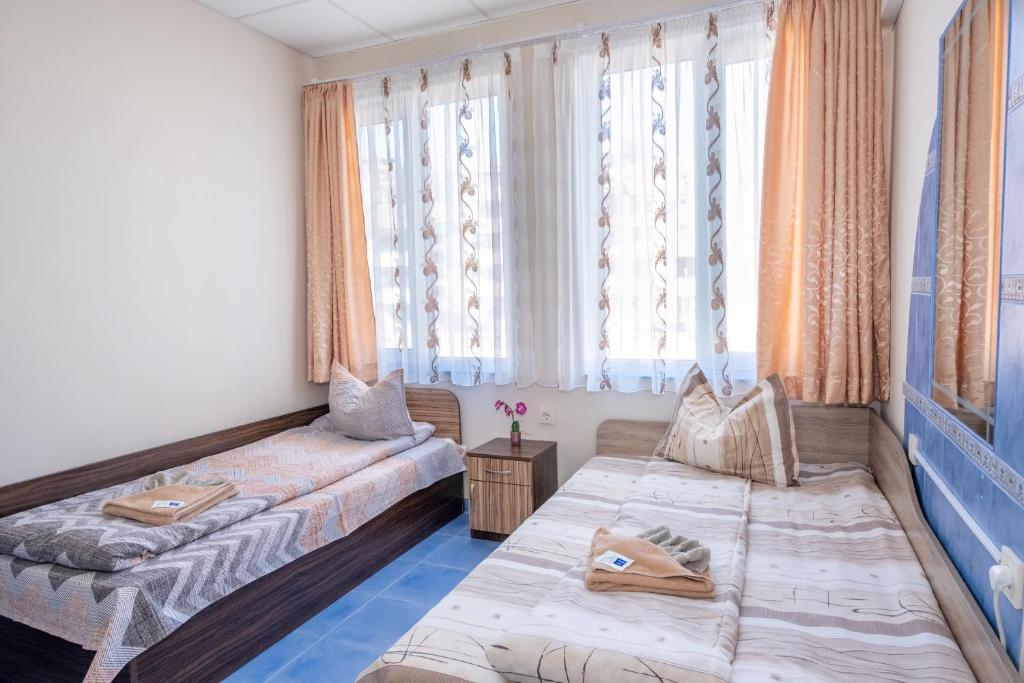 een woonkamer met 2 bedden en een raam bij Апартамент Орловска in Gabrovo