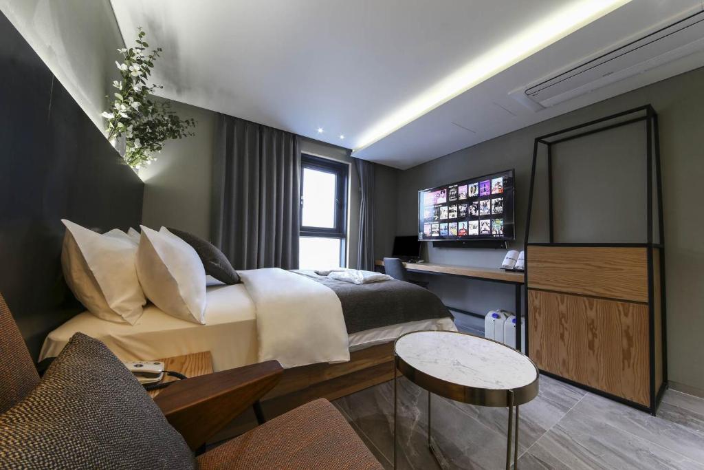 um quarto com uma cama grande e uma televisão em The Post Hotel em Seul