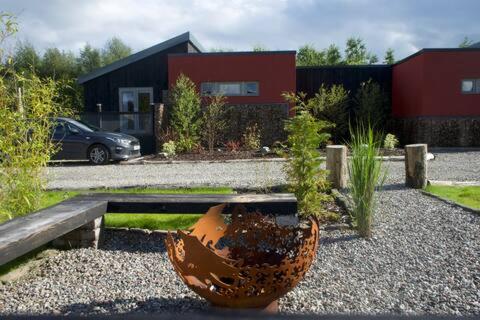 a garden with a large flower pot in front of a house at Byre 1 in Stirling