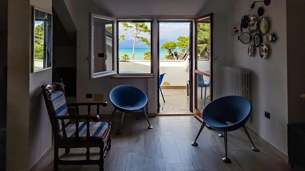 een kamer met stoelen en een tafel met uitzicht op de oceaan bij Attico sul mare in Montesilvano