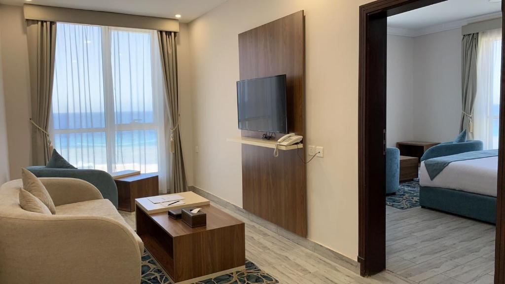 a hotel room with a living room with a bed and a television at SEAVIEW HOTEL in Umm Lajj