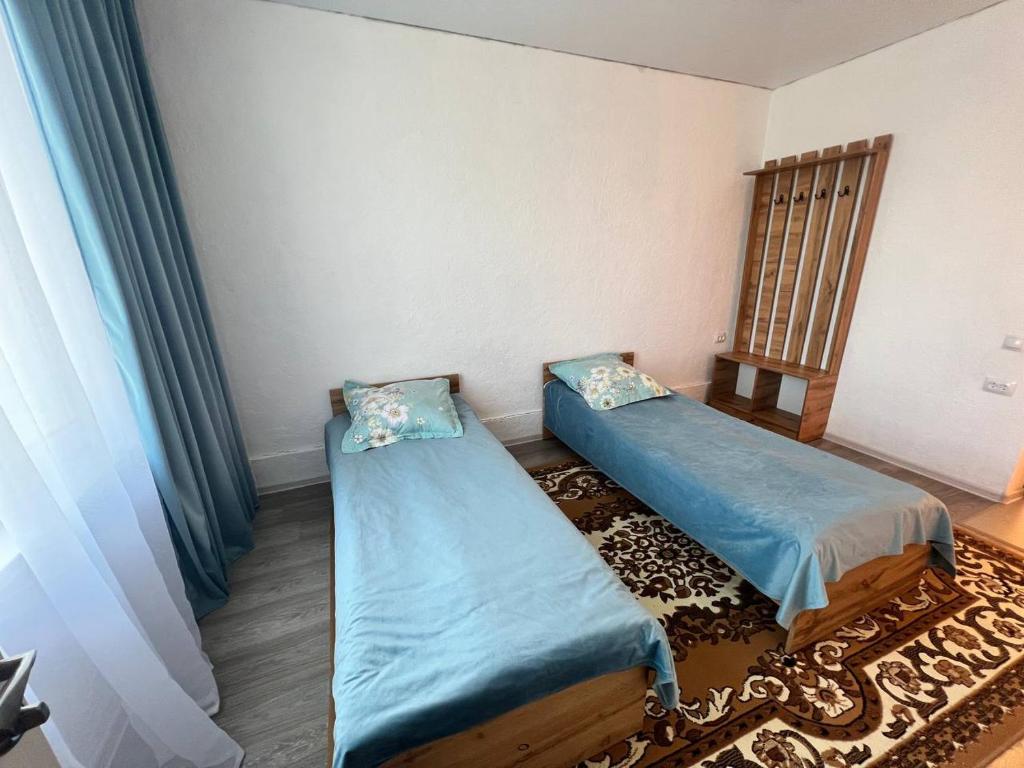 a small room with two beds and a chair at Гостевой дом KOLSAY ROOM in Saty