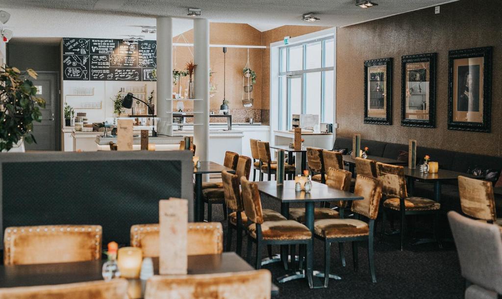 ein Restaurant mit Tischen und Stühlen und eine Bar in der Unterkunft Clarion Collection Hotel Majoren in Skövde