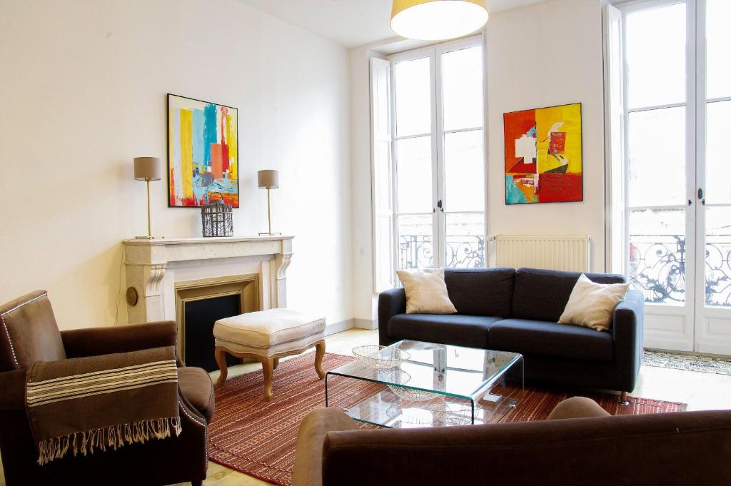a living room with two couches and a fireplace at Condillac - Appartement 2 chambres avec ascenseur et Parking in Bordeaux