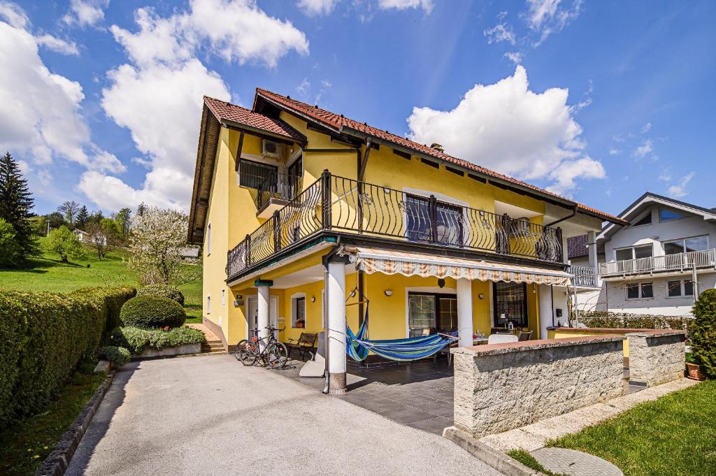 una casa gialla con un balcone sopra di Apartments Vila Lena at Aqualuna a Podcetrtek