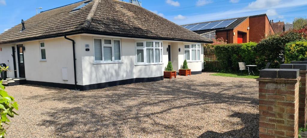 a small white house with a gravel driveway at The Golf Studio Woodhall Spa in Woodhall Spa