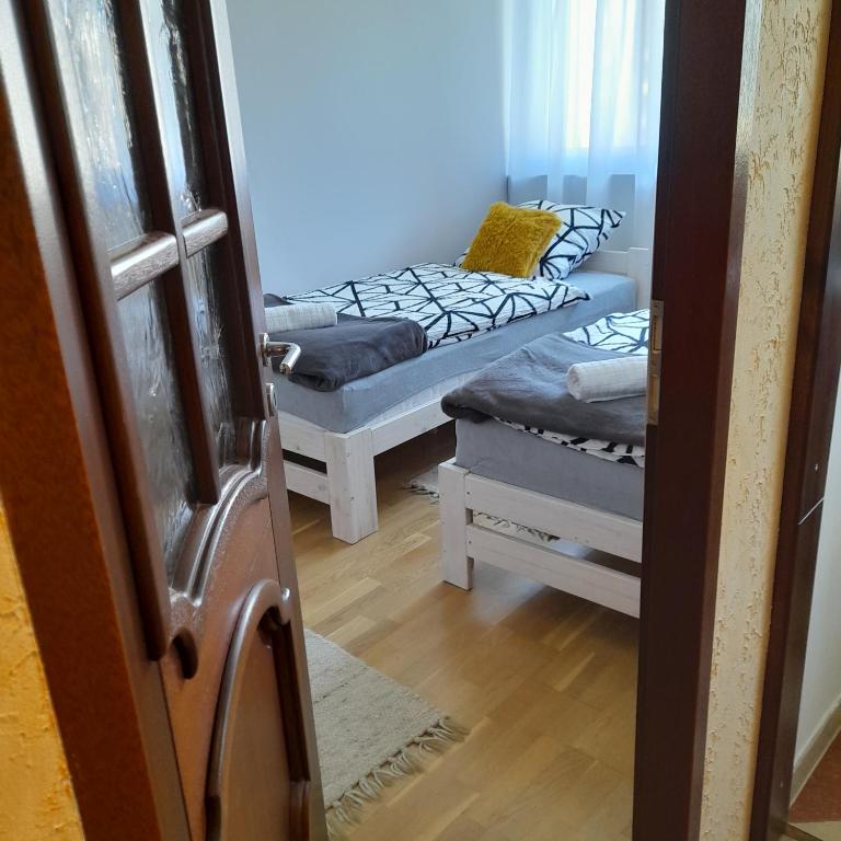 a room with two beds and a door open at Mieszkanie z balkonem in Głuszyca