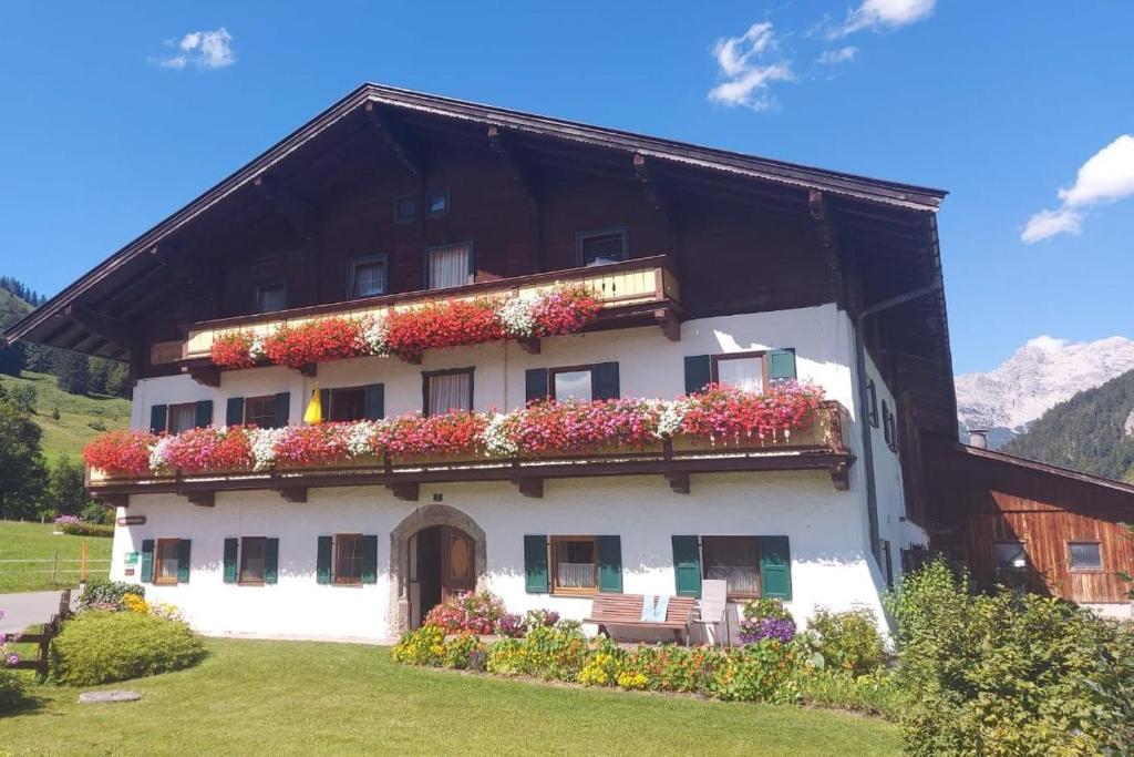 a building with flowers on the side of it at Ferienwohnungen Foidlhof in Hochfilzen